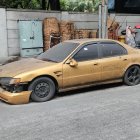 Luxurious golden Porsche car with dragon sculpture parked outdoors.