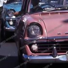 Classic Cars Displayed with Pink Car's Front Grille and Headlights