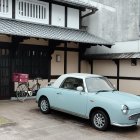 Vintage Car Parked in Front of Graffiti-Covered Building