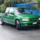 Digitally enhanced image of green ornate semi-truck under cloudy sky