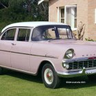 Vintage White Sedan Car Parked with Smiling Man on Lawn