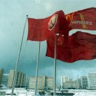 Three flags flying in front of Kremlin and snow-covered ground