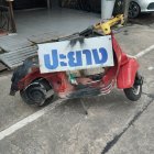 Cargo tricycle with advertising sign toppled on street with parked cars