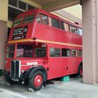 Abandoned red double-decker bus with Cyrillic lettering in ruins