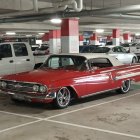 Vintage Red Car Parked in Industrial Garage with Machinery