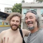 Men with AI-themed beard decorations in front of colorful building.