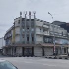 Vintage Black and White Photo: Art Deco Style Cinema with Classic Cars