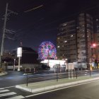 Deserted urban crossroad at night with glowing signs and neon light installation