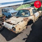 Collection of vintage cars in decay under cloudy sky