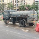 Armored vehicles, child, flying crafts in dystopian cityscape.