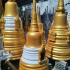 Golden and White Pagodas in Serene Setting with Lush Green Trees