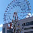 Colorful Ferris Wheel and Ornate Turquoise Building Against Blue Sky