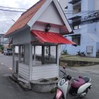 Surreal house entrance with giant mouth, cyclist with pony, whimsical backdrop.