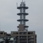 Monochrome image of modern multi-level architecture with cone-shaped roof in misty surroundings.