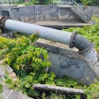 Abandoned outdoor scene with rusty machinery and overgrown foliage