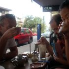 Three People Eating Burgers in City Diner Scene