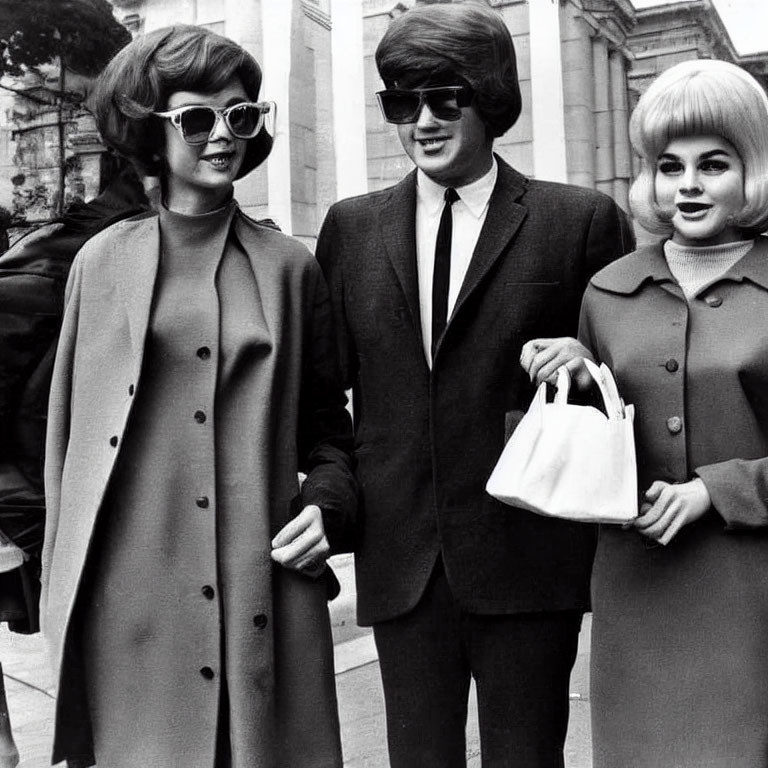 Three individuals in retro fashion with large sunglasses and stylish coats walking confidently.