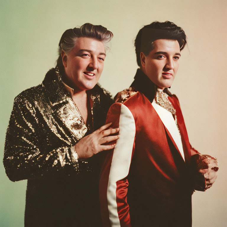 Two Elvis Presley impersonators in sparkling outfits on gradient background