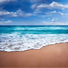 Sandy beach meeting turquoise ocean under cloudy sky