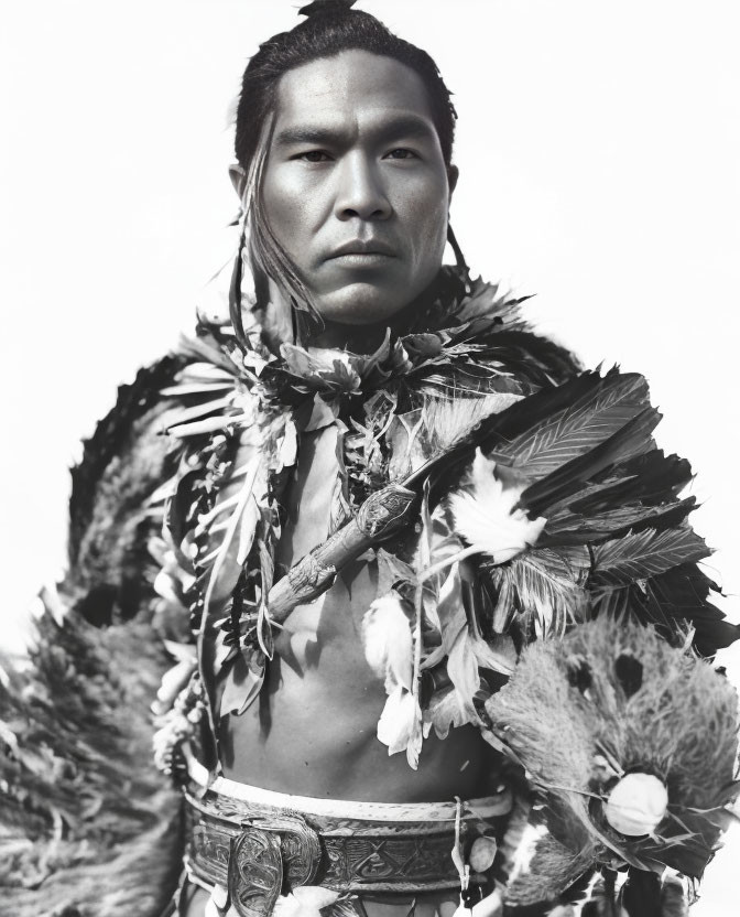 Man in traditional feathered attire staring at camera