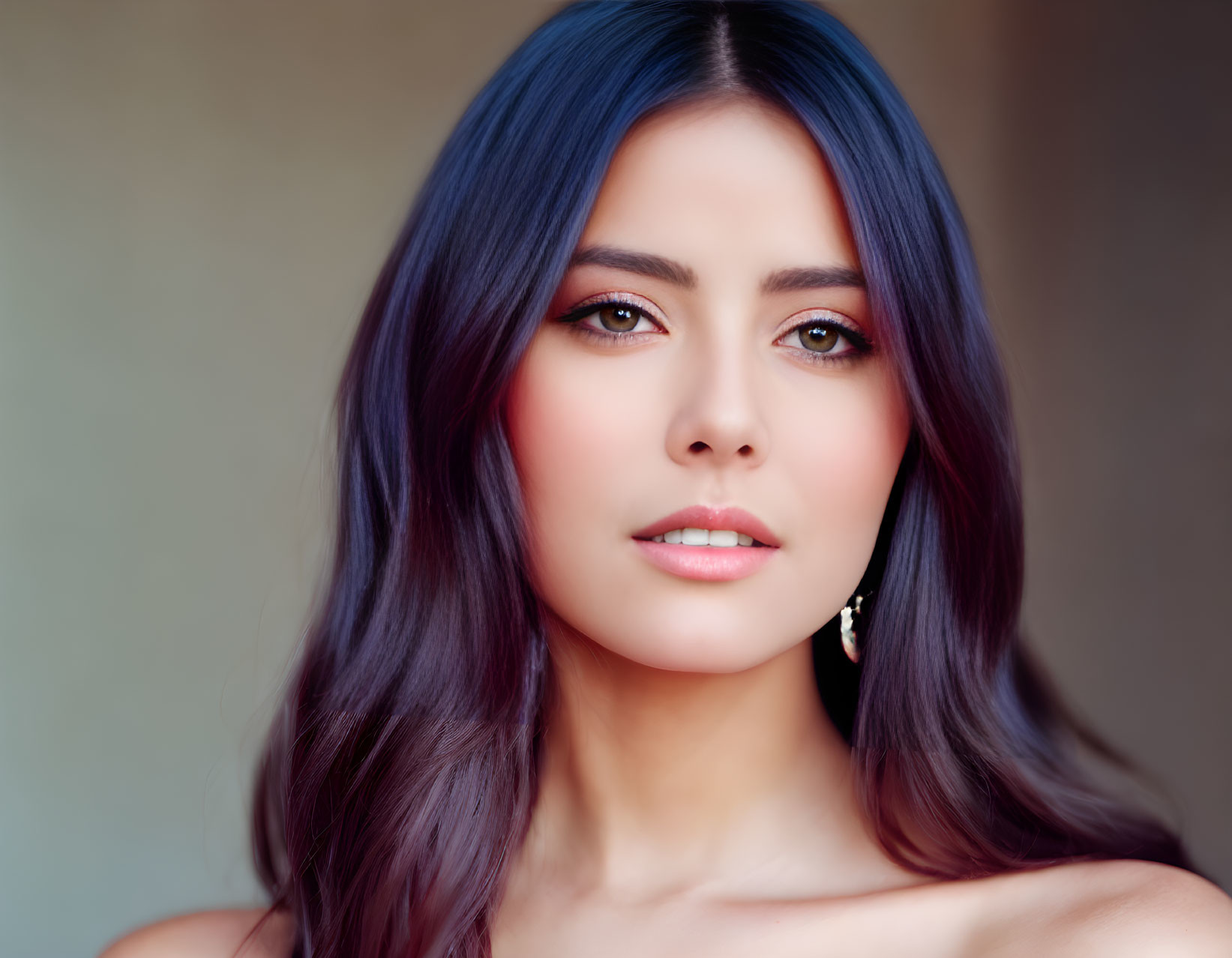 Portrait of woman with dark blue hair and light makeup gazing at camera