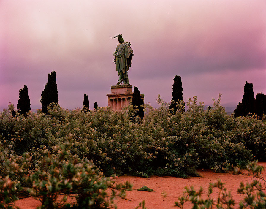 Statue on Pedestal in Greenery under Purple Sky