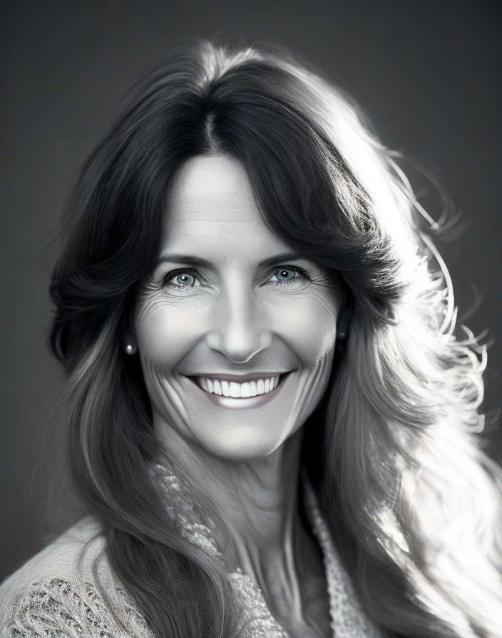 Smiling woman with long hair in black and white portrait