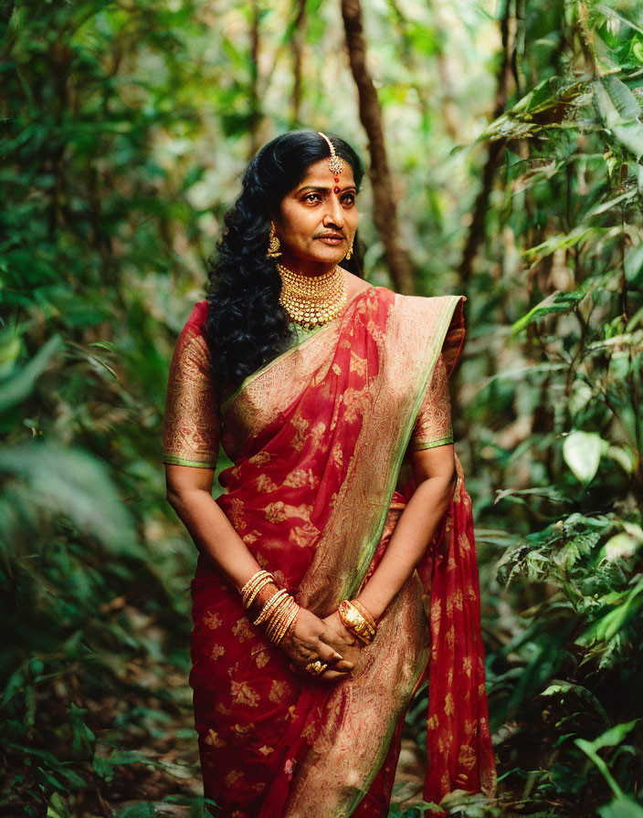 Traditional Red Saree and Gold Jewelry Woman in Lush Greenery