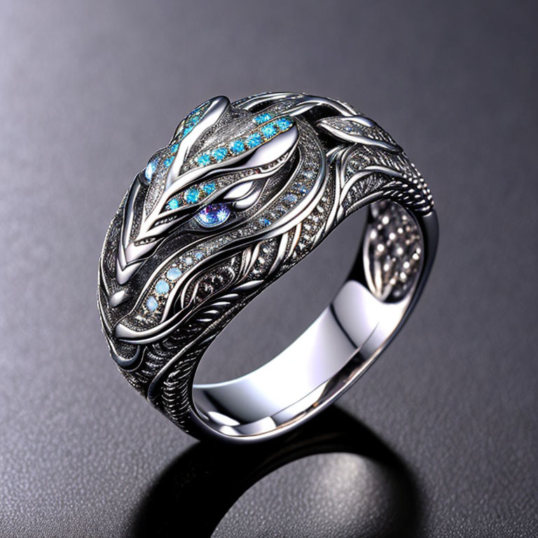 Silver ring with leaf pattern and blue/clear crystals on dark background