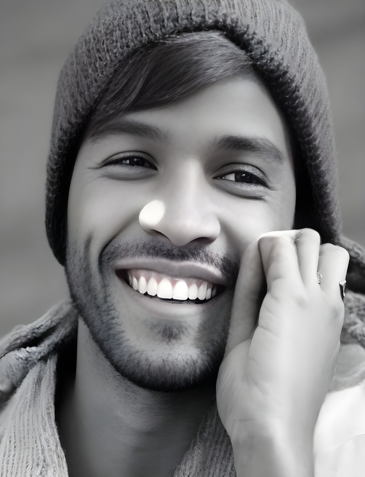 Smiling person with beanie, scruffy beard, and bright teeth portrait