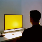 Silhouette profile of person at computer with bright yellow screen