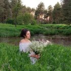 Woman in White Dress by Tranquil Pond with Pink Flowers