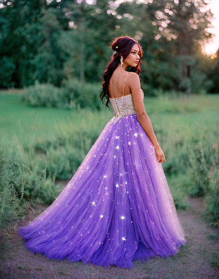 Person wearing LED-lit purple dress in field at dusk