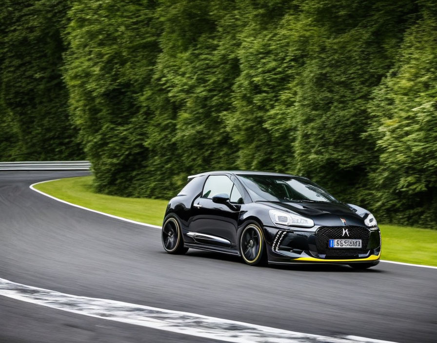 Dynamic black sports hatchback speeding on lush racetrack.