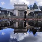 Neoclassical mansion reflected in pond at dusk