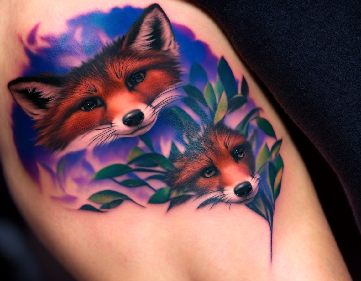 Realistic foxes tattoo in purple and green foliage on upper arm