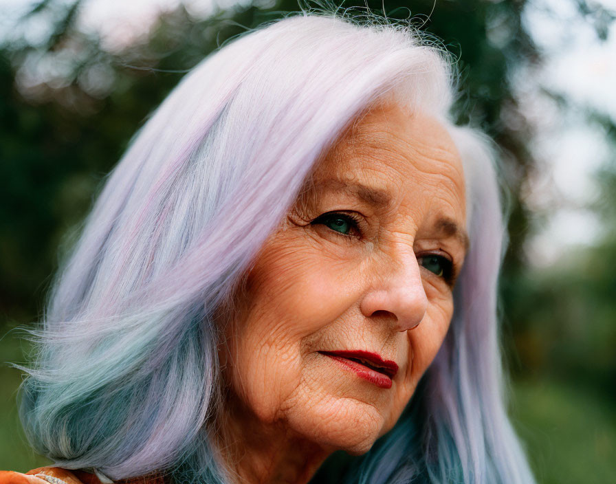 Elderly woman with pastel purple hair and red lipstick on blurred green background