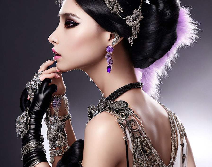 Profile view of woman with elegant makeup, elaborate updo, ornate jewelry, black gloves on grey