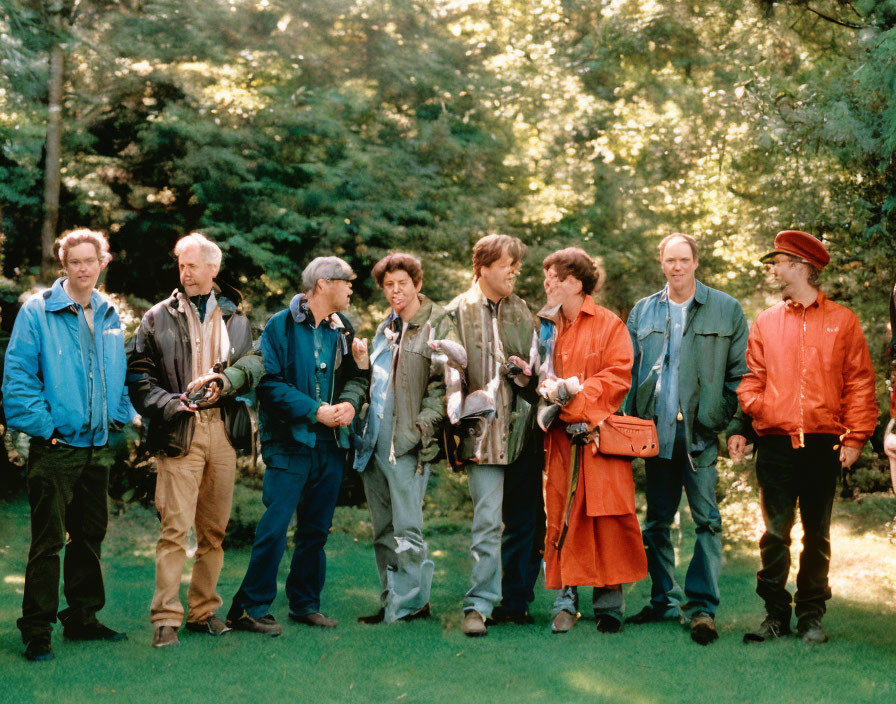 Eight people in a park with cameras and binoculars.