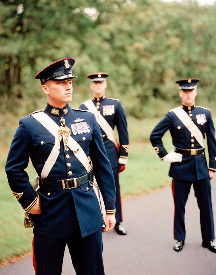 Military personnel in uniform with medals, white belts, and dress hats