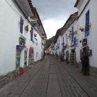 Historic village scene with cobblestone street, period costumes, antique lamps, old-style houses,