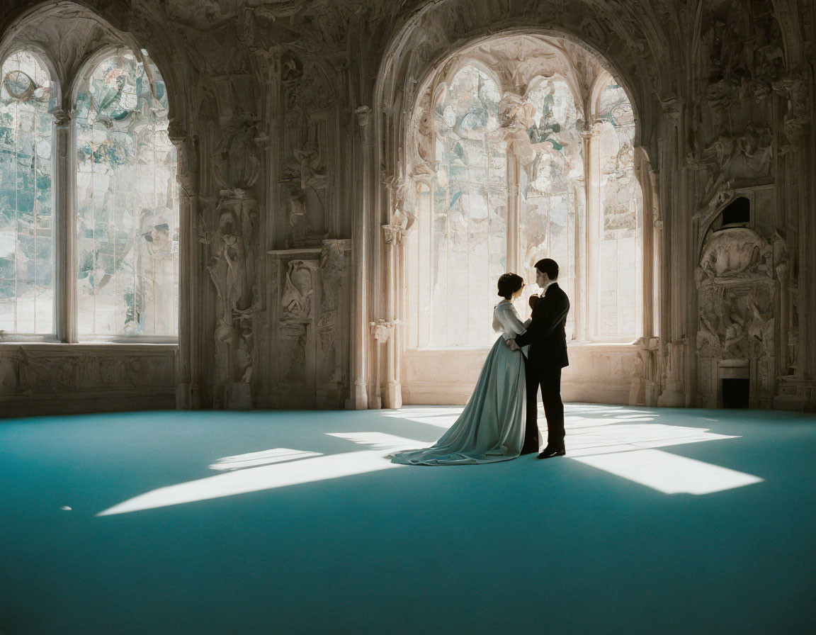 Couple embracing in sunlit ornate room with intricate windows