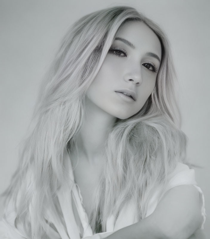 Monochrome portrait of woman with long wavy hair and thoughtful expression