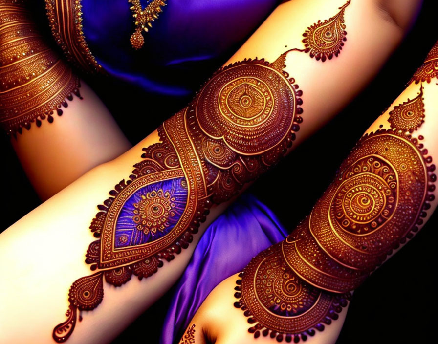 Detailed henna arm designs on person in blue against dark backdrop