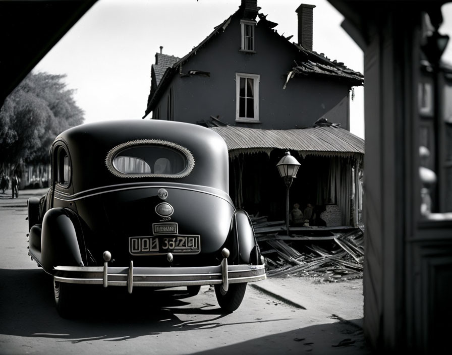 Vintage car in front of damaged buildings in black and white photo