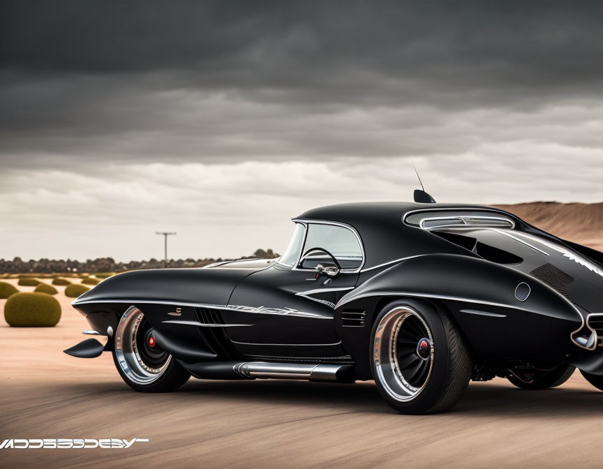 Vintage black sports car with unique curves and fins on a road under cloudy skies