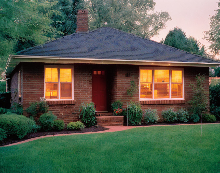 Single-story brick house with shingled roof in dusk setting