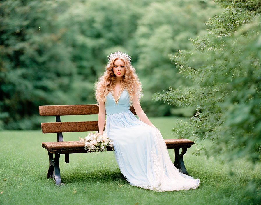 Woman in Blue Dress with Floral Crown Sitting on Park Bench Holding Flowers