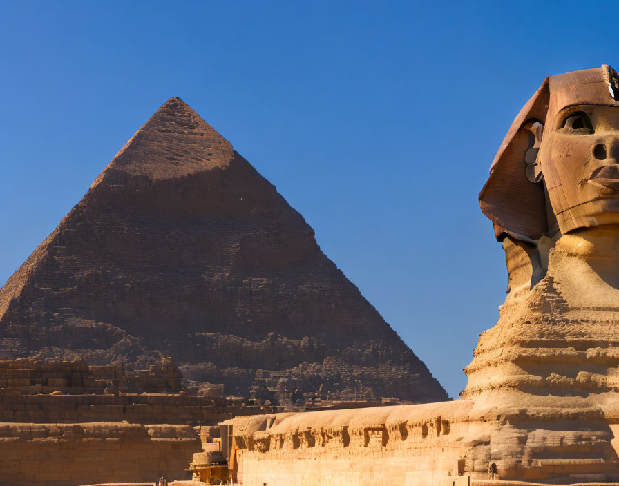 Great Sphinx profile with Khafre Pyramid against clear blue sky