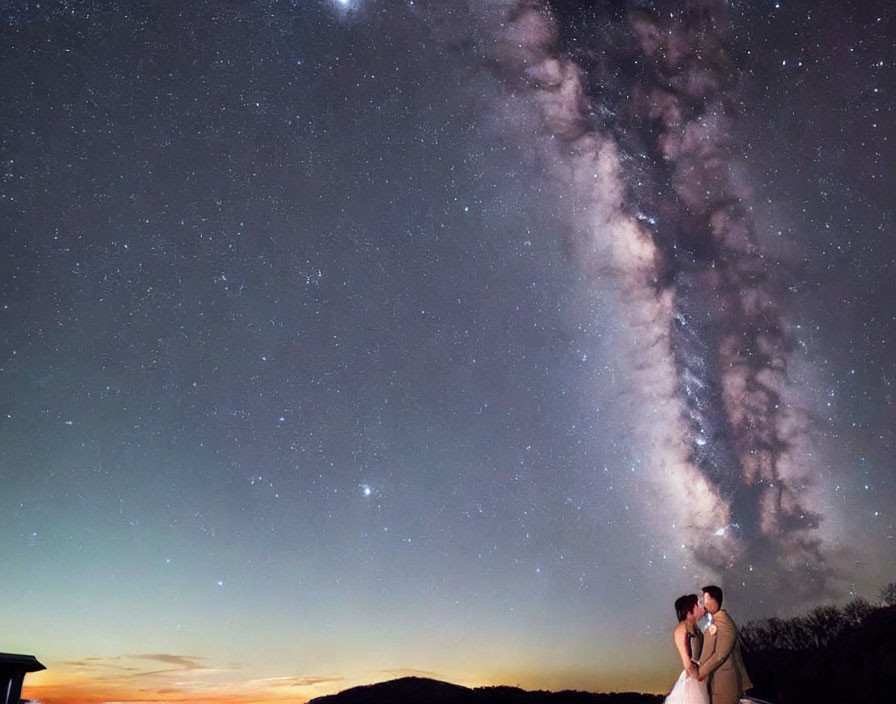 Romantic couple under starry sky with Milky Way galaxy and twilight gradient.